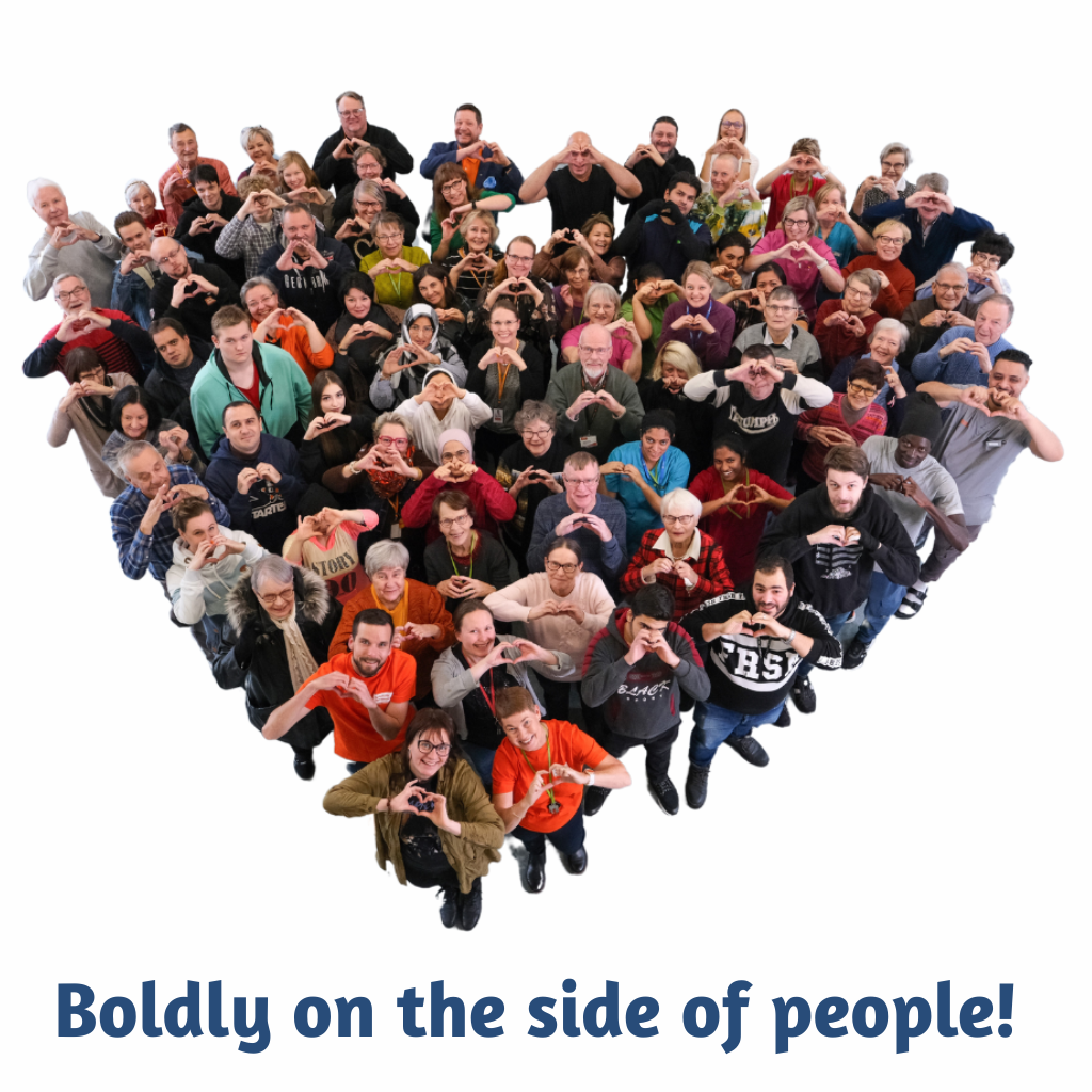 Paople standing inside a heart shape. Written: Boldly on the side of people.